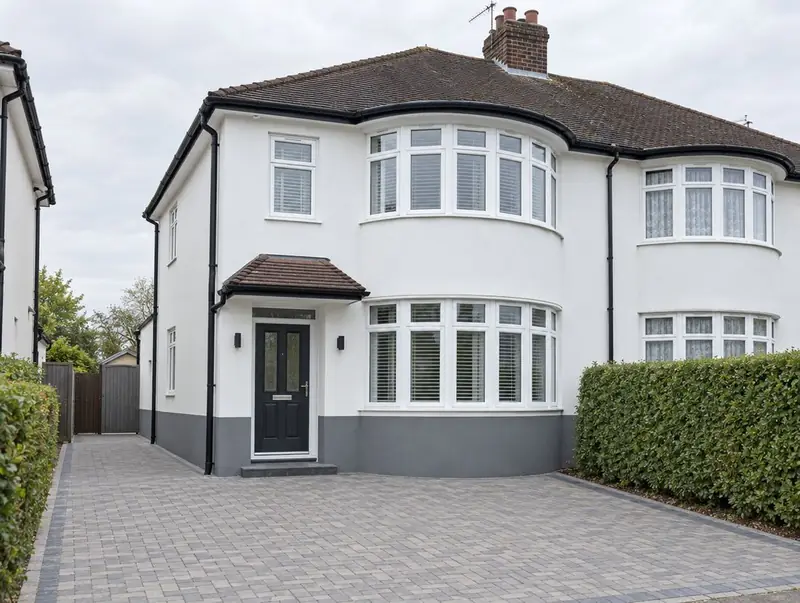 Bay-fronted 1930s semi finished in white silicone render with a grey plinth